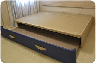 Cama nido con el arrastre saliendo por los pies de la cama